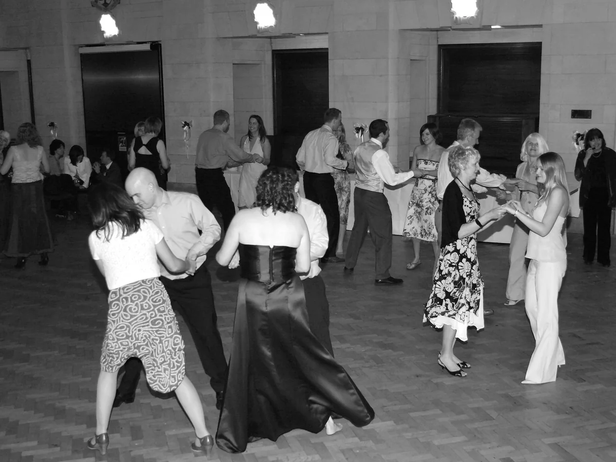 Guests dancing together on a wooden dance floor at a Scottish evening