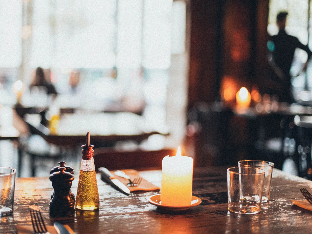 A candlelit restaurant table set for an evening dinner